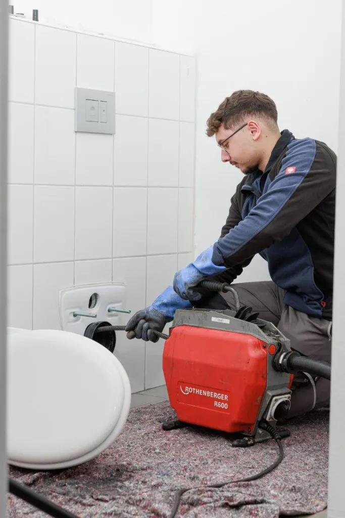 Mann mit Rohrreinigungsmaschine