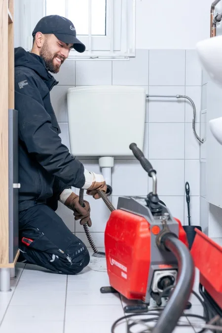 Rohrreiniger mit Maschine bei der Arbeit